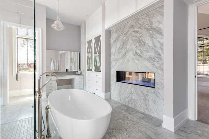 An elegant white marble bathroom remodeling with fireplace for Yuba City, California home